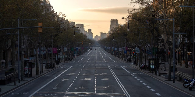 An avenue is seen empty in Barcelona, Spain, Sunday, March 15, 2020. Spain's government announced Saturday that it is placing tight restrictions on movements and closing restaurants and other establishments in the nation of 46 million people as part of a two-week state of emergency to fight the sharp rise in coronavirus infections. For most people, the new coronavirus causes only mild or moderate symptoms. For some, it can cause more severe illness, especially in older adults and people with existing health problems. (AP Photo/Joan Mateu)