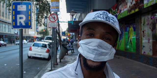 A man wears a face mask in downtown Johannesburg, South Africa, Friday, March 20, 2020. 