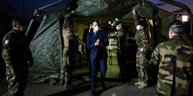 Macron wears a face mask during his visit at the military field hospital in Mulhouse on Wednesday. (Mathieu Cugnot/Pool via AP)