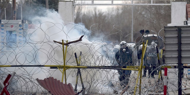 Greek border guard use teargas to push back migrants who try to enter Greece, at Pazarkule border gate, Edirne, Turkey, Saturday, Feb. 29, 2020. (Ismail Coskun/IHA via AP)