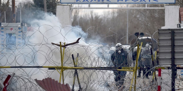 Greek border guard use teargas to push back migrants who try to enter Greece, at Pazarkule border gate, Edirne, Turkey, Saturday, Feb. 29, 2020. (Ismail Coskun/IHA via AP)