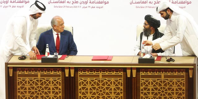 U.S. peace envoy Zalmay Khalilzad, left, and Mullah Abdul Ghani Baradar, the Taliban group's top political leader sign a peace agreement between Taliban and U.S. officials in Doha, Qatar, Saturday, Feb. 29, 2020. (AP Photo/Hussein Sayed)