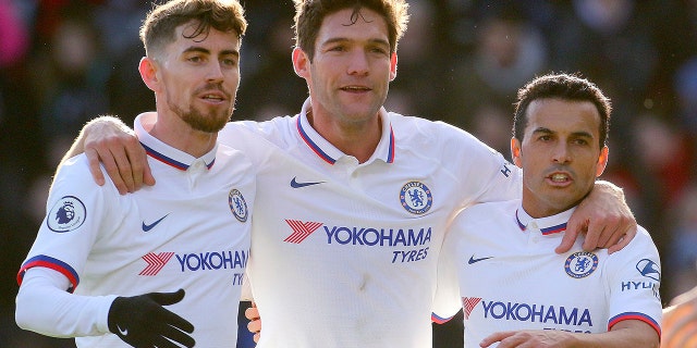 Chelsea's Marcos Alonso, centre, celebrates with team-mates Jorginho, left, and Pedro after scoring his side's first goal of the game against Bournemouth, in the English Premier League soccer match at the Vitality Stadium in Bournemouth, England, Saturday Feb. 29, 2020. (Mark Kerton/PA via AP)