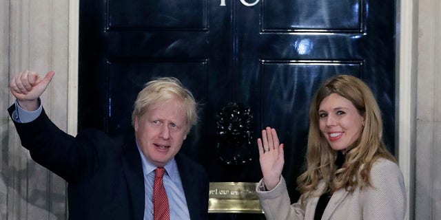 Britain's Prime Minister Boris Johnson and his partner Carrie Symonds wave from the steps of number 10 Downing Street in London, in December 2019.  (Associated Press)