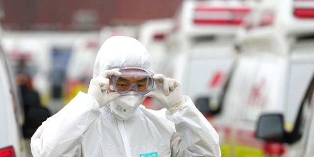 A health worker wearing a protective suit adjusts his goggles as he prepares to transport patients in Daegu, South Korea, Sunday, March 1, 2020. The coronavirus has claimed its first victim in the United States as the number of cases shot up in Iran, Italy and South Korea and the spreading outbreak shook the global economy.(Ryu Young-seok/Yonhap via AP)