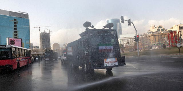 A police vehicle disinfects streets against coronavirus in Tehran, Iran, Sunday, March 1, 2020. While the new coronavirus has extended its reach across the world, geographic clusters of infections were emerging, with Iran, Italy and South Korea seeing rising cases. (AP Photo/Vahid Salemi)