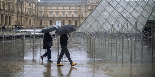 People walk by the Louvre museum, in Paris, France.(AP Photo/Rafael Yaghobzadeh)
