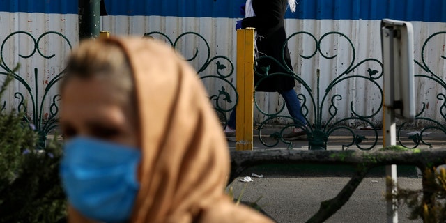 Pedestrians wearing face masks walk on the sidewalks in northern Tehran, Iran, Sunday, March 1, 2020. While the new coronavirus has extended its reach across the world, geographic clusters of infections were emerging, with Iran, Italy and South Korea seeing rising cases. (AP Photo/Vahid Salemi)