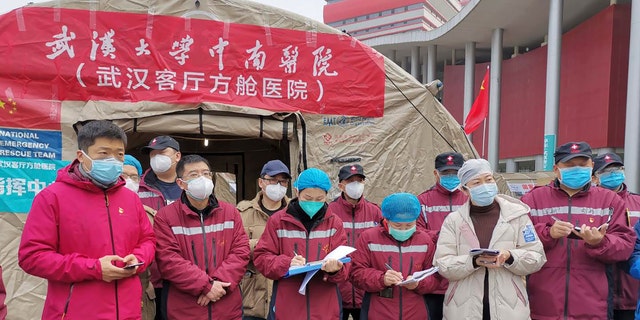 Medical workers attend a a morning conference outside a tent on the square in front of the Wuhan Living Room Temporary hospital in Wuhan in central China's Hubei province in this February photo. 