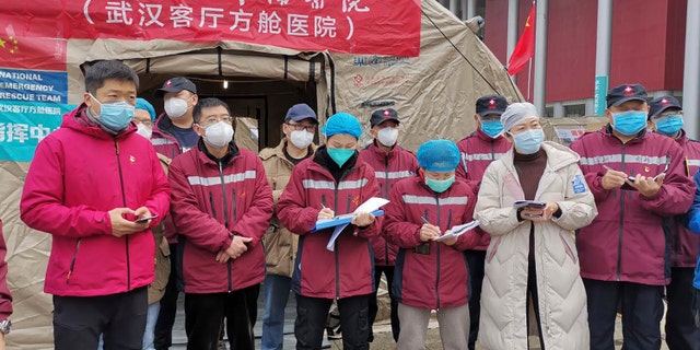 Medical workers attend a a morning conference outside a tent on the square in front of the Wuhan Living Room Temporary hospital in Wuhan in central China's Hubei province in this February photo.