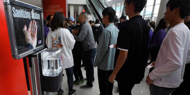 Fans walk by a sanitizing station at Staples Center prior to an NBA basketball game between the Los Angeles Clippers and the Philadelphia 76ers Sunday, March 1, 2020, in Los Angeles. (AP Photo/Mark J. Terrill)