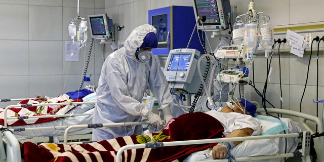 In this Sunday, March 1, 2020 photo, a medic treats a patient infected with coronavirus, at a hospital in Tehran, Iran. (Ali Shirband/Mizan News Agency via AP)