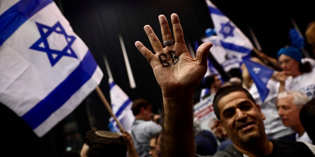 Supporter of Israeli Prime Minister Benjamin Netanyahu displays his hand with BB written on it for Netanyahu's nickname "Bibi" as they celebrate after first exit poll results for Israeli elections in Tel Aviv, Israel, Monday. (AP Photo/Oded Balilty)