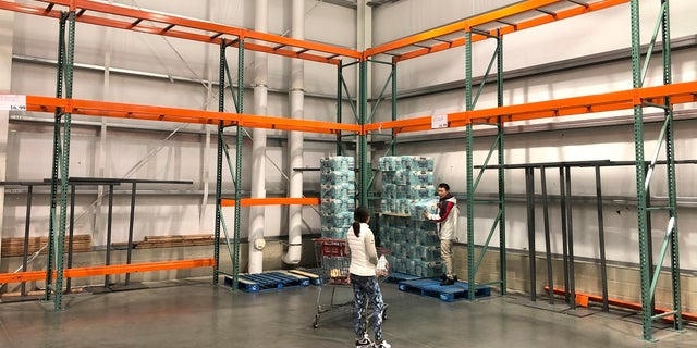 Customers take some of the last paper towels off a palette in a Costco store in Teterboro, N.J., earlier this month. (AP Photo/Seth Wenig)