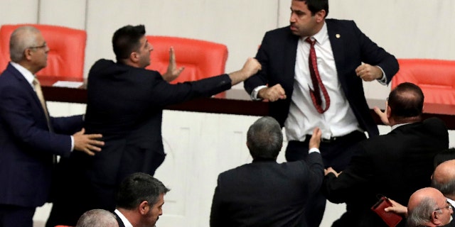 Legislators push each other as a brawl breaks out in Turkey's parliament in Ankara, Turkey, Wednesday, March 4, 2020. A fight broke out in the Turkish parliament between lawmakers from opposing parties during a tense discussion about Turkey's military involvement in northwest Syria. (AP Photo)