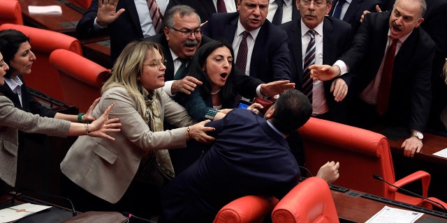 Legislators push each other as a brawl breaks out in Turkey's parliament in Ankara, Turkey, Wednesday, March 4, 2020. A fight broke out in the Turkish parliament between lawmakers from opposing parties during a tense discussion about Turkey's military involvement in northwest Syria. (AP Photo)