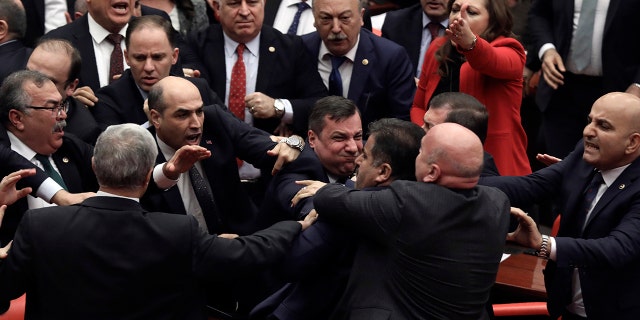 Legislators push each other as a brawl breaks out in Turkey's parliament in Ankara, Turkey, Wednesday, March 4, 2020. A fight broke out in the Turkish parliament between lawmakers from opposing parties during a tense discussion about Turkey's military involvement in northwest Syria. (AP Photo)