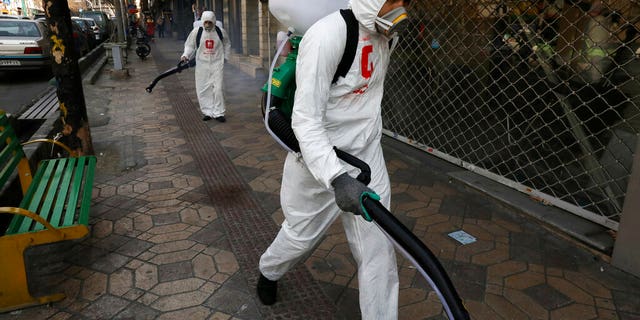 Firefighters disinfect a sidewalk to help prevent the spread of the new coronavirus in Tehran, Iran, Thursday, March 5, 2020. Iran has one of the highest death tolls in the world from the new coronavirus outside of China, the epicenter of the outbreak. (AP Photo/Vahid Salemi)