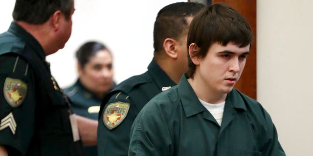 FILE: Dimitrios Pagourtzis, the Santa Fe High School teenage student accused of killing 10 people in a May 2018 shooting at the high school, is escorted by Galveston County Sheriff's Office deputies into the jury assembly room for a change of venue hearing at the Galveston County Courthouse in Galveston, Texas. 