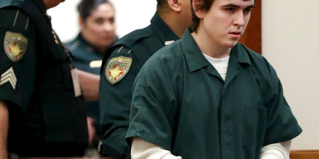 FILE: Dimitrios Pagourtzis, the Santa Fe High School teenage student accused of killing 10 people in a May 2018 shooting at the high school, is escorted by Galveston County Sheriff's Office deputies into the jury assembly room for a change of venue hearing at the Galveston County Courthouse in Galveston, Texas.