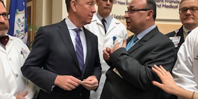 Connecticut Gov. Ned Lamont, second from left, listening to Dr. Danyal Ibrahim of Trinity Health Of New England, second from right, after a news conference about the state's response to the new coronavirus at St. Francis Hospital and Medical Center in Hartford, Conn.