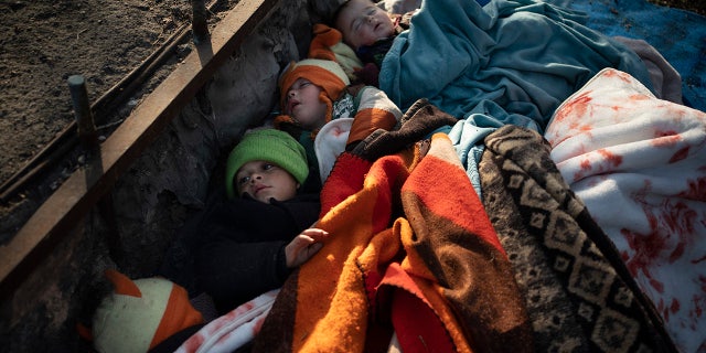 Children from Syria sleep outside at a bus station in Edirne, near the Turkish-Greek border, Saturday, March 7, 2020. Thousands of refugees and other migrants have been trying to get into EU member Greece in the past week after Turkey declared that its previously guarded borders with Europe were open. (AP Photo/Felipe Dana)