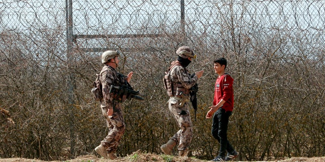 Turkish special police officers patrol by the fence on the Turkish-Greek border in Pazarkule, Turkey, Saturday, March 7, 2020. Thousands of migrants headed for Turkey's land border with Greece after Erdogan's government said last week that it would no longer prevent migrants and refugees from crossing over to EU territory. (AP Photo/Darko Bandic)