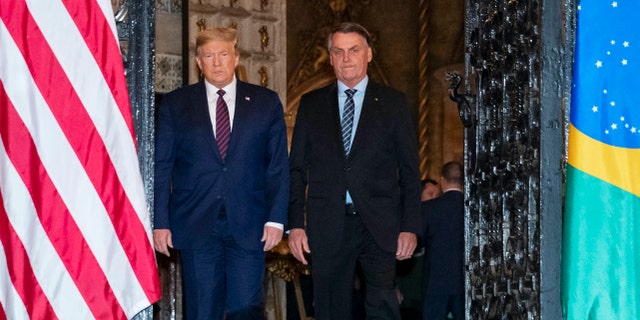 President Donald Trump arrive before a dinner with Brazilian President Jair Bolsonaro at Mar-a-Lago, Saturday, March 7, 2020, in Palm Beach, Fla. (AP Photo/Alex Brandon)