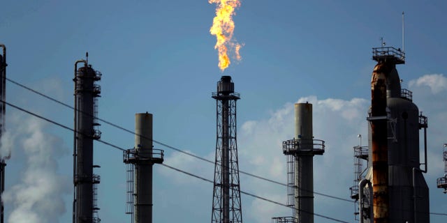 A flame burns at the Shell Deer Park oil refinery in Deer Park, Texas. Oil prices are plunging Sunday, March 8, 2020, amid worries that an OPEC dispute will lead a virus-weakened economy to be awash in an oversupply of crude. (AP Photo/Gregory Bull, File)