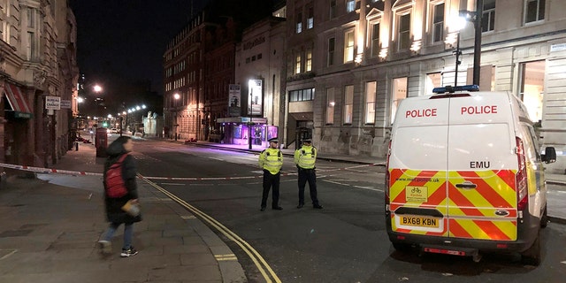 Police stand guard by a cordoned off area after an incident in Westminster, London, early Monday, March 9, 2020. British police say they have shot dead a man who was brandishing two knives near Trafalgar Square in central London. The Metropolitan Police force said Monday that the shooting was not related to terrorism. (Scott D'Arcy/PA via AP)