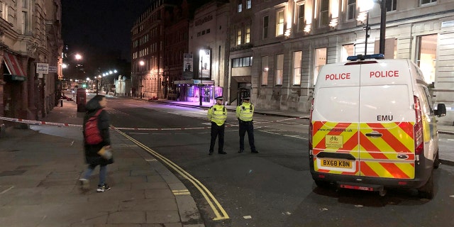 Police stand guard by a cordoned off area after an incident in Westminster, London, early Monday, March 9, 2020. British police say they have shot dead a man who was brandishing two knives near Trafalgar Square in central London. The Metropolitan Police force said Monday that the shooting was not related to terrorism. (Scott D'Arcy/PA via AP)
