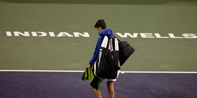 FILE - In this Monday, March 11, 2019, file photo, Novak Djokovic, of Serbia, walks off the court during a rain break in his match against Philipp Kohlschreiber, of Germany, at the BNP Paribas Open tennis tournament in Indian Wells, Calif. The BNP Paribas Open tennis tournament, set to begin Wednesday, March 11, 2020, has been postponed after a case of coronavirus was confirmed in the Coachella Valley. (AP Photo/Mark J. Terrill, File)