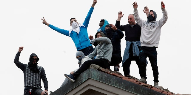 Inmates stage a protest against new rules to cope with coronavirus emergency, atop the roof of the San Vittore prison in Milan, Italy, Monday, March 9, 2020. Italy took a page from China's playbook Sunday, attempting to lock down 16 million people — more than a quarter of its population — for nearly a month to halt the relentless march of the new coronavirus across Europe. (AP Photo/Antonio Calanni)