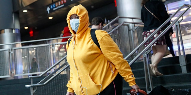 A commuter wears a face mask in the New York City transit system, Monday, March 9, 2020, in New York. New York continued grappling Monday with the new coronavirus, as case numbers, school closings and other consequences grew. (AP Photo/John Minchillo)