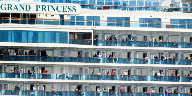 Passengers aboard the Grand Princess celebrate in March as they return to the U.S. after being held at sea for days because of COVID-19. (AP Photo/Noah Berger)