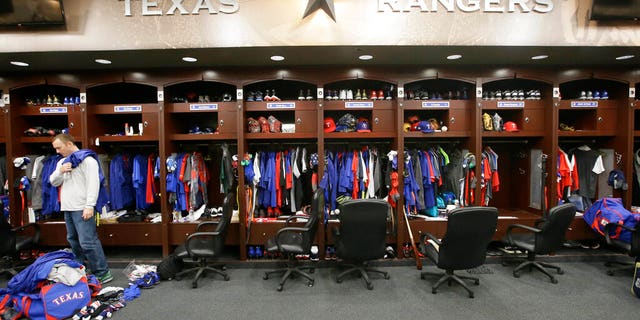 Texas Rangers pitcher Sam Dyson, left, packs a bag in the locker room at the baseball park in Arlington, Texas.
