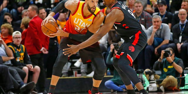Toronto Raptors center Serge Ibaka (9) guards against Utah Jazz center Rudy Gobert (27) in the first half during an NBA basketball game Monday, March 9, 2020, in Salt Lake City. (AP Photo/Rick Bowmer)