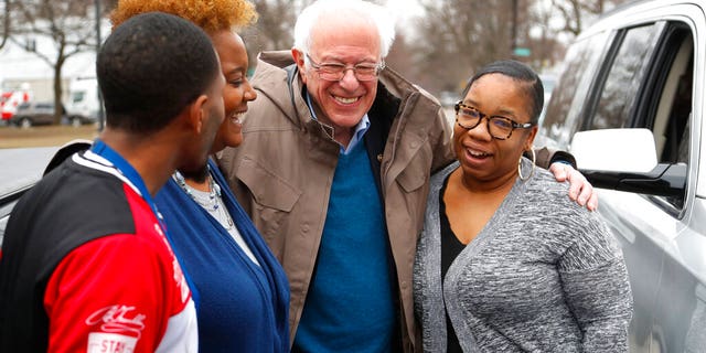 Democratic presidential candidate Sen. Bernie Sanders, I-Vt., visits custodian Davonta Bynes, from left, principal DaRhonda Evans-Stewart and social worker Kim Little outside a polling location at Warren E. Bow Elementary School in Detroit, Tuesday, March 10, 2020. (AP Photo/Paul Sancya)