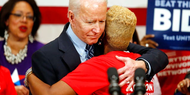 Democratic presidential candidate former Vice President Joe Biden hugs Crystal Turner of Columbus, Ohio, with Moms Demand Action during a campaign rally in Columbus, Ohio, Tuesday, March 10, 2020. (AP Photo/Paul Vernon)