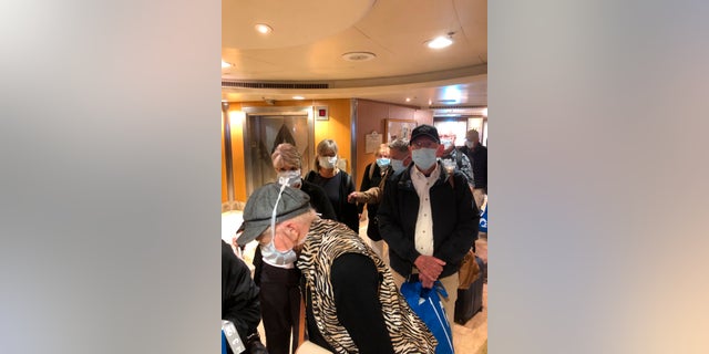 This photo provided by Laurie Miller shows passengers as they get ready to disembark the Grand Princess in Oakland, Calif., Tuesday, March 10, 2020. California Gov. Gavin Newsom urged the state's nearly 40 million residents to avoid sporting events, concerts and large gatherings to prevent the spread of the coronavirus and adamantly warned the elderly to stay away from cruise ships as he pondered measures to restrict cruise travel off the California coast. (Laurie Miller via AP)