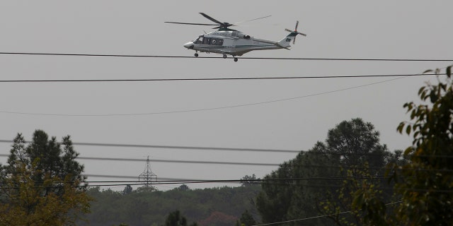 A helicopter hovers over the site of a plane crash in Islamabad, Pakistan, Wednesday, March 11, 2020. Pakistan's air force says one of its fighter jets has crashed in a wooded area near the capital while practicing aerobatic maneuvers. Wednesday's crash was in preparation for National Day celebrations later this month. (AP Photo/B.K. Bangash)