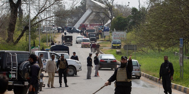 Pakistani authorities cordon off the site of a plane crash in Islamabad, Pakistan, Wednesday, March 11, 2020. Pakistan's air force says one of its fighter jets has crashed in a wooded area near the capital while practicing aerobatic maneuvers. Wednesday's crash was in preparation for National Day celebrations later this month. (AP Photo/B.K. Bangash)