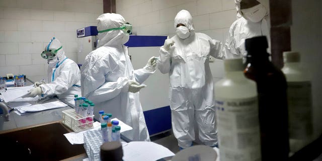 In this Tuesday, March, 10, 2020 photo, paramedics work in a laboratory that tests samples taken from patients suspected of being infected with the new coronavirus, in the southwestern city of Ahvaz, Iran. For most people, the new coronavirus causes only mild or moderate symptoms, such as fever and cough. For some, especially older adults and people with existing health problems, it can cause more severe illness, including pneumonia. (Amin Nazari/ISNA via AP)