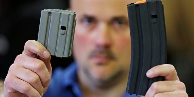 ​​​​​​​Jonathan Scalise, owner of Ammunition Storage Components, holds up a 10-round, left, and a 30-round magazine that his company manufacturers for the AR-15 rifle in New Britain, Conn., April 10, 2013. Gun rights supporters are suing Connecticut officials over part of a 2013 state gun control law passed after the Sandy Hook school shooting, saying it unconstitutionally bans people from loading more than 10 rounds of ammunition into their firearms. (Associated Press)