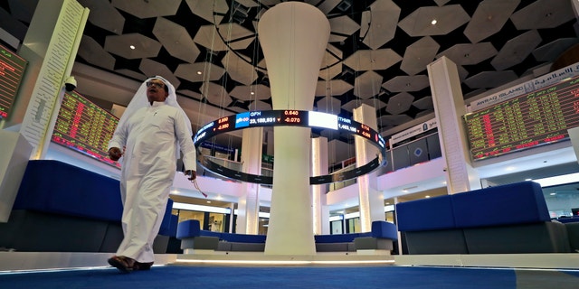 A trader walks at the Dubai Financial Market in Dubai, United Arab Emirates, Thursday, March 12, 2020. Regional stock markets were down, reflecting investor concerns and nerves felt globally as oil prices plunge and tourism revenue is eroded by the virus. The World Health Organization on Wednesday officially designated the outbreak a "pandemic." (AP Photo/Kamran Jebreili)