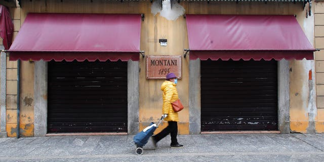 A woman walks in Codogno, Italy, Thursday, March 12, 2020. The northern Italian town that recorded Italy’s first coronavirus infection has offered a virtuous example to fellow Italians, now facing an unprecedented nationwide lockdown, that by staying home, trends can reverse. Infections of the new virus have not stopped in Codogno, which still has registered the most of any of the 10 Lombardy towns Italy’s original red zone, but they have slowed.