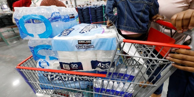 Customers take advantage of the grand opening of a new Costco store in Ridgeland, Miss., to stock up on water and bathroom tissue and cleaning supplies to help deal with coronavirus. (AP Photo/Rogelio V. Solis)