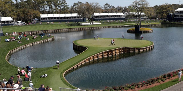 Cameron Champ, Nate Lashley, Kevin Tway and their caddies, walk the 17th green, during the first round of The Players Championship golf tournament Thursday, March 12, 2020 in Ponte Vedra Beach, Fla. (Associated Press)