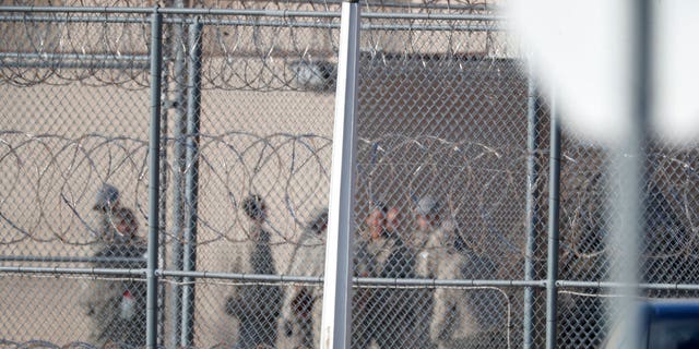 In this Feb. 18, 2020, file photo prisoners stand outside of the federal correctional institution in Englewood, Colorado. (AP Photo/David Zalubowski, File)