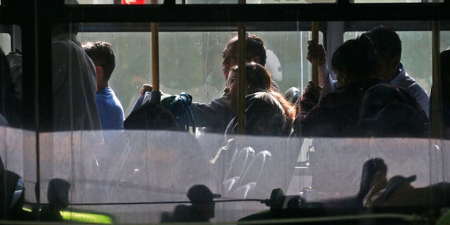 Passengers sit on a bus at the main bus station in Guatemala City on Friday. Guatemala has halted deportation flights of its nationals from the U.S. in the wake of the coronavirus outbreak. (AP)